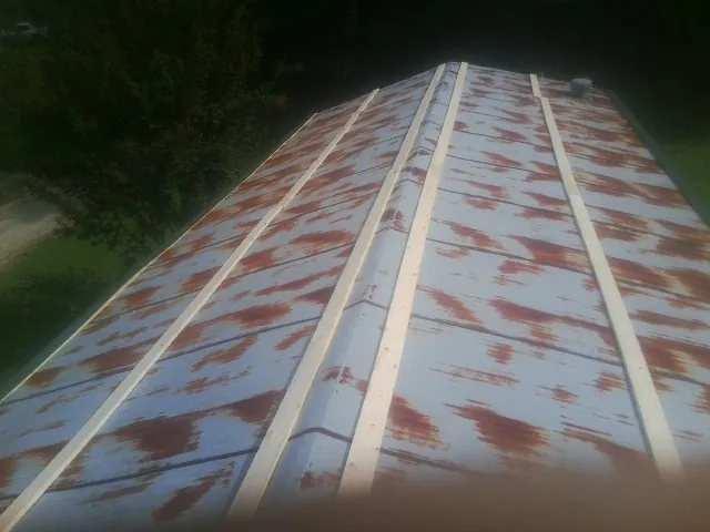 Rusted metal roof panels with new wood purlins before replacement — Storm Damage Roof Repair in Maupin by Roofing Brothers
