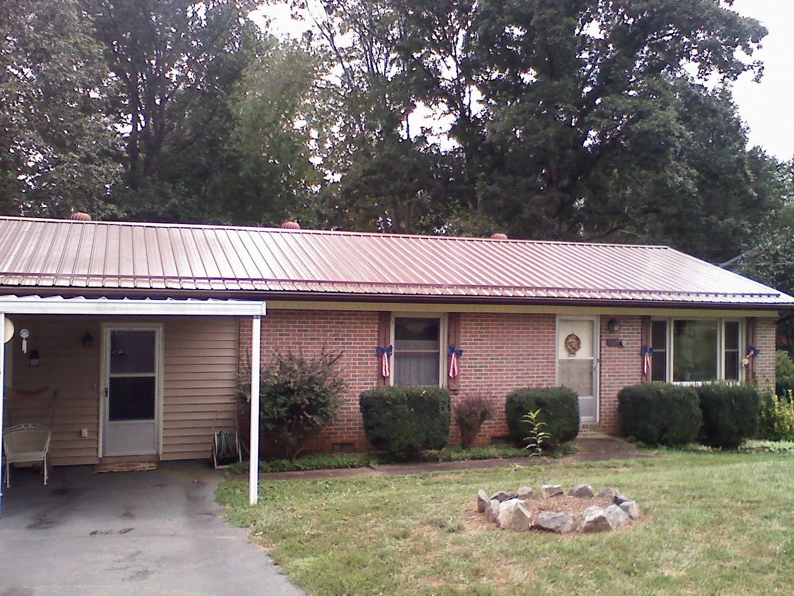 Bronze metal roof and carport on a brick ranch home — Roof Repair work by our crew in Maupin
